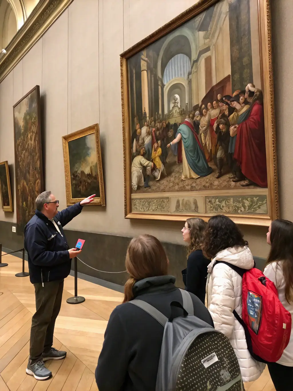 A photograph showcasing a guided tour at LES TRESORS DE LISETTE, with a knowledgeable guide explaining the historical significance of an exhibit to a group of adults.